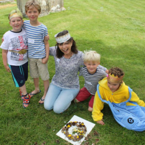 Sally and the boys with their completed nature crown made with fir cones and flowers